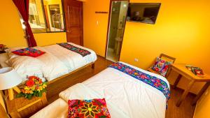 库斯科Andean Atoq Hostel的一间卧室配有两张床和一张带台灯的桌子
