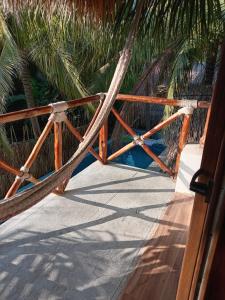 El Paredón Buena VistaEl Puente的棕榈树门廊上的吊床