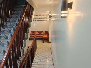 卢纳将军城#2 Green Room Inn Siargao的走廊上设有楼梯,远处设有沙发