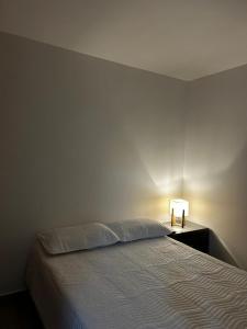 图卢阿Hospedaje LIZ的一间卧室配有一张床和一张桌子上的台灯