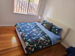 Oakleigh EastTranquil and cosy guest house的卧室内的一张带蓝色棉被和枕头的床