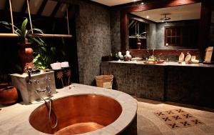 丹戎Hotel Tugu Lombok - CHSE Certified的浴室配有木制浴缸和水槽