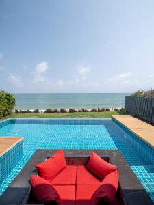 班克鲁特阳光天堂度假酒店的游泳池旁设有红色沙发