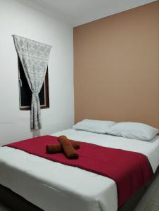 珍南海滩Lawer Guesthouse (Pulau Langkawi)的一张带红色毯子和窗户的床