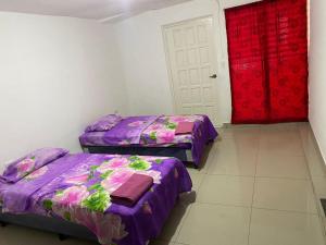 马那瓜La Mezcla Perfecta Hostal的一间设有两张床和红色门的房间