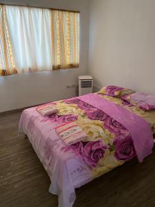 马那瓜La Mezcla Perfecta Hostal的一间卧室配有一张带粉色和黄色毯子的床