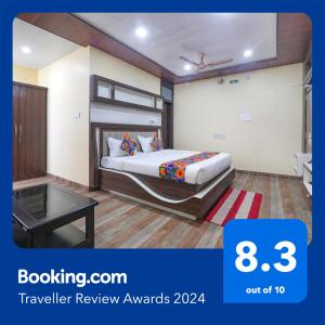 瓦拉纳西FabHotel Saumendra的酒店客房配有一张床铺和一张桌子。