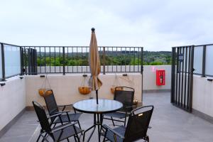 堪培拉Japanese Penthouse Retreat 1B1B 2 Parking 5-min tram-to-CBD Brekky Wifi Netflix的阳台配有桌椅和遮阳伞