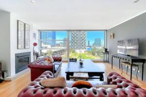 墨尔本Luxury 4B Docklands Penthouse water city views的带沙发和大窗户的客厅