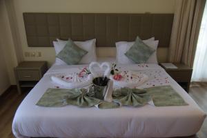 MauaSpringWells Hotel ltd的床上配有毛巾和拖鞋