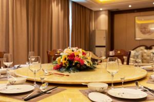 Lancang澜沧华隆大酒店的桌子上放着眼镜和一束鲜花