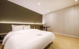 浦项Hotel Venesian的卧室配有一张白色大床和一张书桌