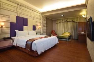 台南夏阁精品汽车旅馆 的酒店客房设有一张大床和一台电视。
