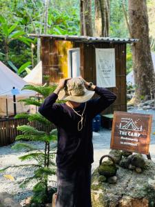 Ban Pok NaiThe camp Maekampong的戴帽子的人站在标志旁