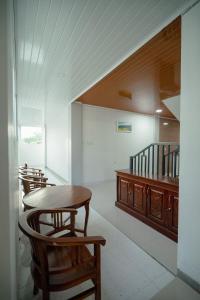 纳闽巴霍La Geiro Villa Labuan Bajo的配有桌椅和楼梯的房间