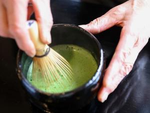 高山Fukeikan 風景館的把一壶绿液体装在 ⁇ 子上的人