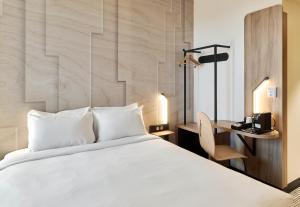 RocquencourtB&B HOTEL Versailles Rocquencourt的配有一张床和一张书桌的酒店客房