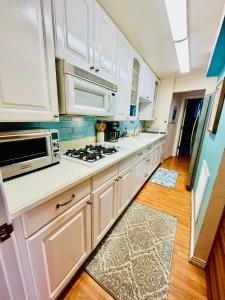 圣地亚哥La Playa Place Getaway的厨房配有白色橱柜和炉灶烤箱。