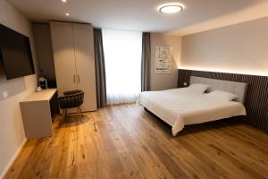 维尔Hotel Rondo - Self-Check-in的卧室设有白色的床和大窗户