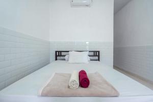 乌鲁瓦图SDK Homestay Uluwatu的一间卧室配有一张床,上面有两条毛巾