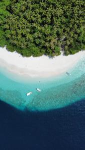 KendhooFasdheythere Inn Maldives的享有海滩的空中景色,在水中划船