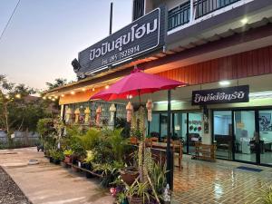 Ban Laoปัวปันสุขโฮม (Puapan Suk Home)的前面有粉红色伞的餐厅