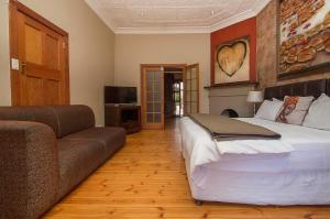 约翰内斯堡萨福隆斯宾馆 的一间卧室配有一张大床和一张沙发