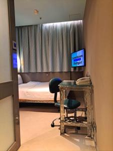 香港工業家酒店的客房设有一张床和一张带椅子的桌子