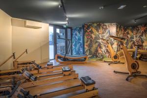 夏蒙尼-勃朗峰Lykke Hotel Chamonix - ex Mercure的健身房设有数辆健身自行车和壁画