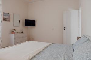 丽都迪奥斯蒂亚La Casa di Betty的一间白色卧室,配有床和电视