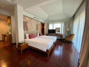 Phayayen帕特拉瓦纳度假酒店的卧室配有一张白色大床和一张书桌