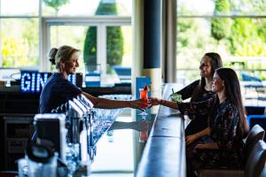 巴德瓦尔特斯多夫Spa Resort Styria- ADULTS ONLY的两个女人在酒吧摇手
