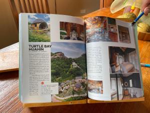 考陶Turtle Bay Eco Luxe Hua Hin的一张带有度假村照片的开放式书籍