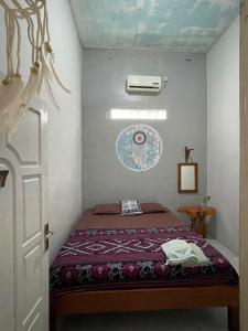 卡里蒙贾瓦Loyal friend hostel karimunjawa的一间小房间的卧室,配有一张床铺
