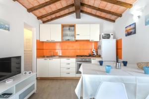 SantʼIlario in CampoCasa Arancio的厨房配有白色橱柜和白色冰箱。