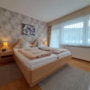 特里滕海姆Wein- und Gästehaus Lentes的一间卧室设有一张大床和一个窗户。