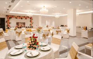 范兰德凡Triptam Vrindavan的宴会厅配有白色的桌子和白色的椅子