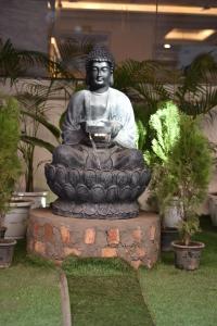 新德里HOTEL YASH PALACE的佛陀雕像坐在喷泉里