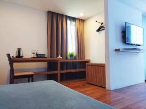 阿罗士打The Leverage Lite Hotel - Kuala Kedah的酒店客房配有书桌和电视。