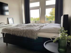 库克斯港Ferienwohnung PIER 2 in Cuxhaven的一间卧室配有一张带桌子和窗户的床