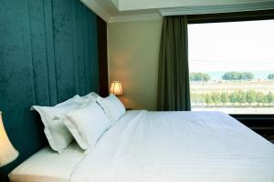 奥朱贝尔Hola Hotel的卧室配有一张大白色床和窗户