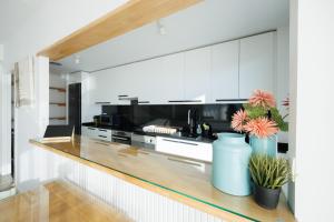 巴达洛纳Gran Apartmento Playa Badalona的厨房配有白色橱柜和黑色家电