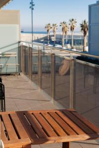 巴达洛纳Gran Apartmento Playa Badalona的海滩旁一座建筑的顶部木凳