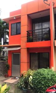 道伊斯2BR 2BT home with pool between Tagbilaran and Panglao的一座红色的建筑,前面有植物