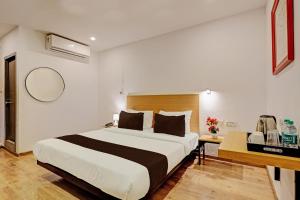 新德里Ocean Suites Near Delhi International Airport的一间卧室配有一张大床和一张书桌