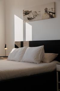 巴达洛纳Gran Apartmento Playa Badalona的卧室内的一张带白色床单和枕头的床