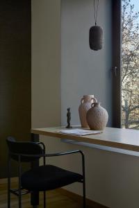 雅典Athens Woo Suites的椅子和花瓶在房间柜台上
