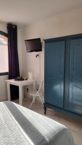 弗尔东河畔维农圆桌宾馆的一间卧室配有蓝色的床和一张书桌
