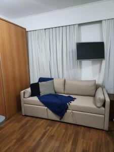 圣保罗Hotel Slavieiro Moema Suite Prime Familia的带沙发和电视的客厅