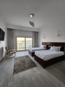 阿斯旺NUB INN的酒店客房设有两张床和大窗户。
